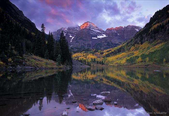 Maroon Peak, 14156' and North Maroon Peak, 14,014' are reflected in Maroon Lake at sunrise. Peak autumn color in the aspen forest...